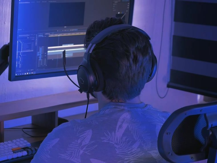 Persona con audífonos editando un video en su computador